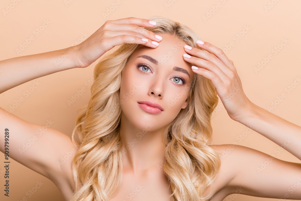 Fototapeta premium Portrait of attractive wavy-haired girl touching perfect skin clear pore cleansing scrub isolated over beige pastel color background