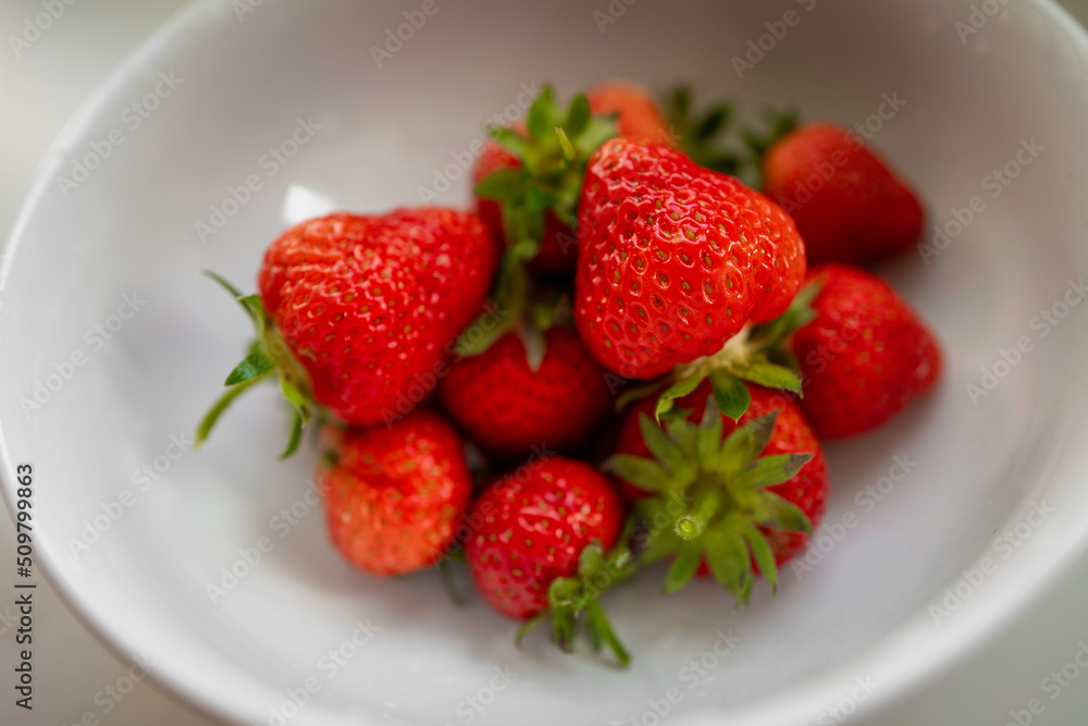 Ripen fresh red strawberry fruits in the white bowl, close-up from the diagonal top Ripen fresh red strawberry fruits in the white bowl, close-up from the diagonal top