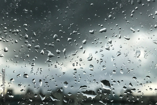 Abstract background with rain drops on window and blurred daylight