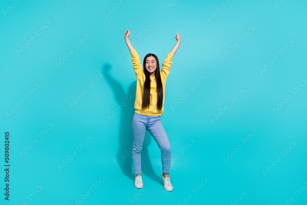Full length photo of impressed lucky woman wear yellow pullover rising fists isolated teal color background