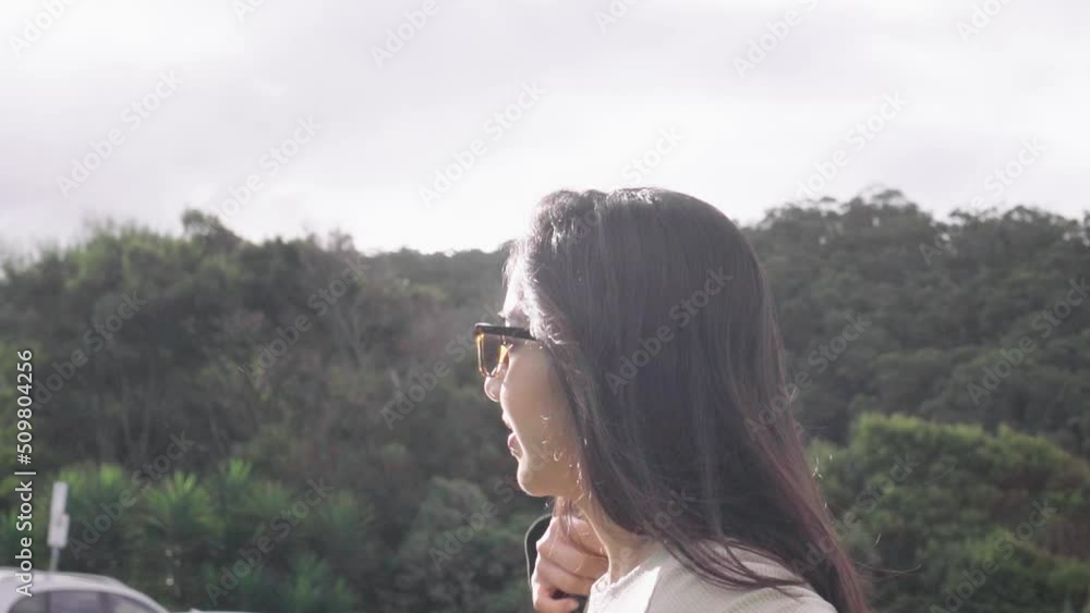 Female in sunglasses wearing a jacket under glaring sun rays along Great Ocean Road, Victoria, Australia Female in sunglasses wearing a jacket under glaring sun rays along Great Ocean Road, Victoria, Australia