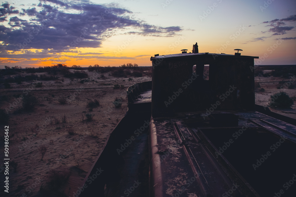 Cemetery of old ships on the former bank of Aral sea during sunrise, Muynak, Uzbekistan