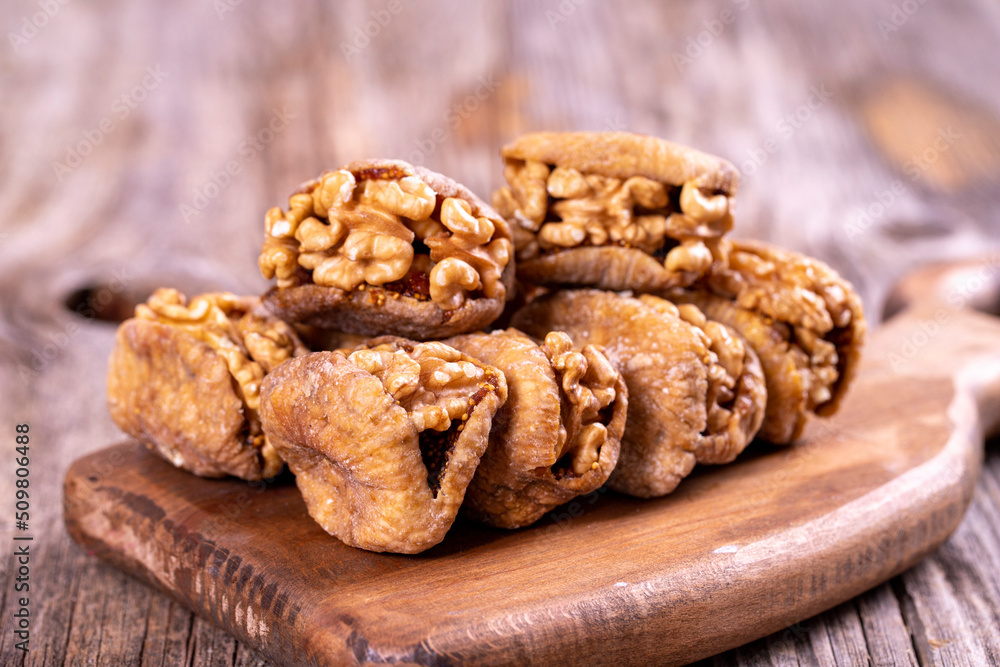 Stuffed dried figs. Dried figs stuffed with walnuts on a wood floor. Close-up. local name cevizli incir Stuffed dried figs. Dried figs stuffed with walnuts on a wood floor. Close-up. local name cevizli incir