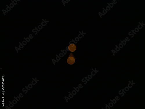 mysterious small, luminous orange circles on a black background