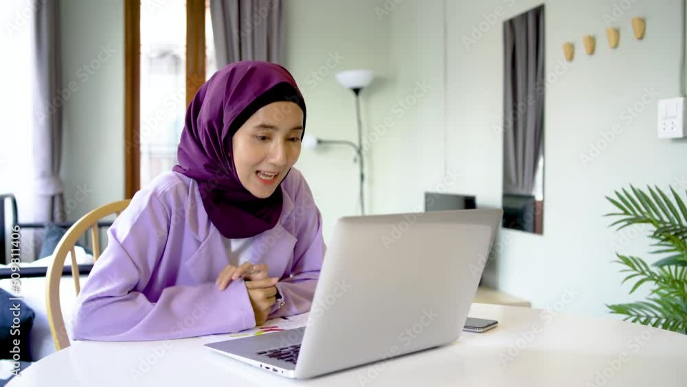 Laptop video call. Internet communication. Online chat, Smiling asia arab people young woman wear hijab headscarf talking to friend on notebook web conference on desk at home living room. Laptop video call. Internet communication. Online chat, Smiling asia arab people young woman wear hijab headscarf talking to friend on notebook web conference on desk at home living room.
