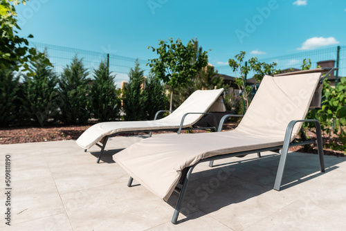 Two gray sun loungers by the pool. Relax in the backyard of a country house