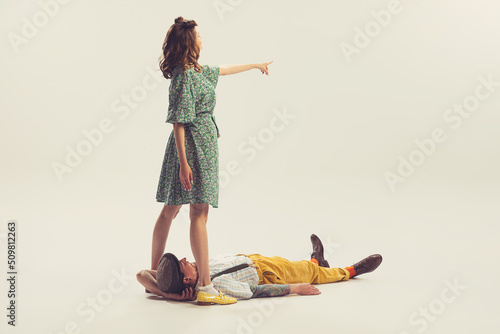 Studio shot of young man and girl in vintage retro style outfits psoing isolated on white background. Concept of relations, family, 1960s american fashion style and art.