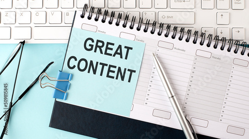 фотографія GREAT CONTENT text on blue sticker on planning and keyboard,blue background