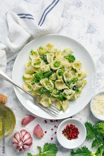 Italian pasta - orecchiette with turnip greens on light background. Mediterranean diet. Top view.