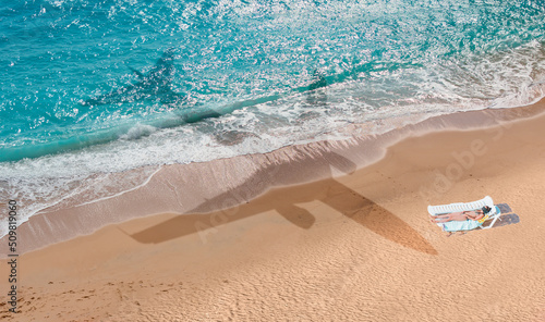 Beautiful girl sunbathing on the bach - Airplane travel to exotic destination with shadow of passenger airplane flying above beautiful tropical beach - Antalya, Turkey