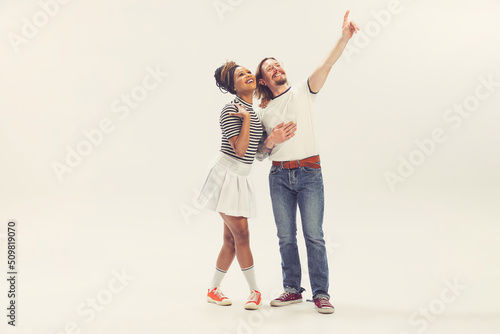 Delighted young man and woman in vintage retro style outfits running isolated on white background. Timeless traditions, 1960s american fashion style and art.