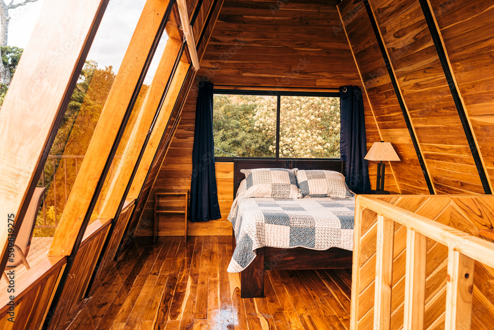 Image of the interior of a beautiful log cabin bedroom with a cozy bed. Image of the interior of a beautiful log cabin bedroom with a cozy bed.