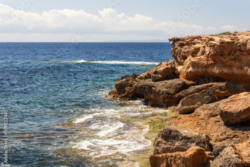 Krast cape cliffs stretching into the blue mediterranean sea in Ibiza, Balearic Islands, Spain