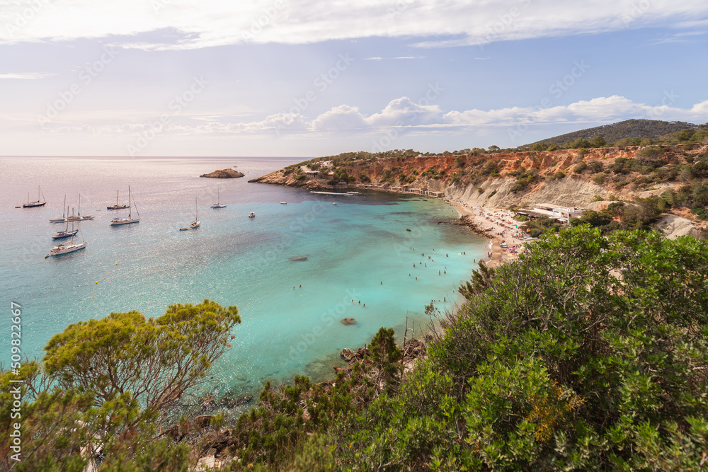 Obraz premium Beautiful view of Ibiza island beach Cola d'Hort in the rays of the setting sun. Balearic Islands, Spain