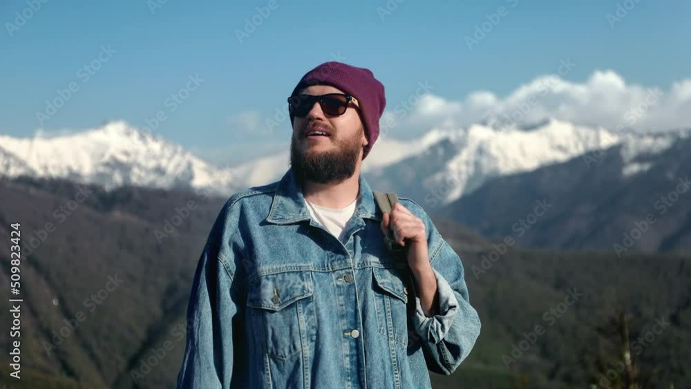 Portrait of handsome satisfied bearded hiker man standing in the mountains. Tourist enjoy nature Portrait of handsome satisfied bearded hiker man standing in the mountains. Tourist enjoy nature