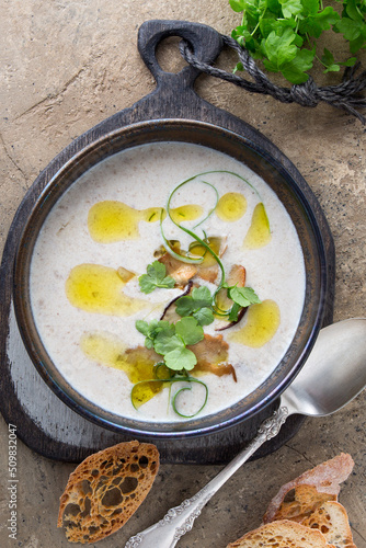 a bowl of creamy porcini mushroom soup on a light table