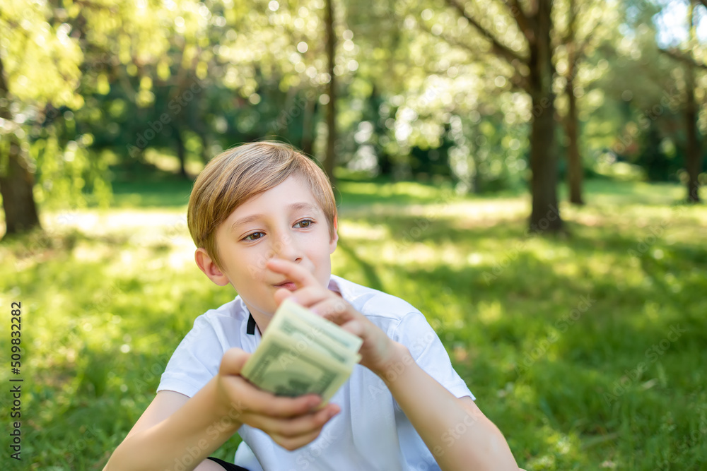 the boy sits in the park and thinks he is holding a pack of dollar bills the boy sits in the park and thinks he is holding a pack of dollar bills