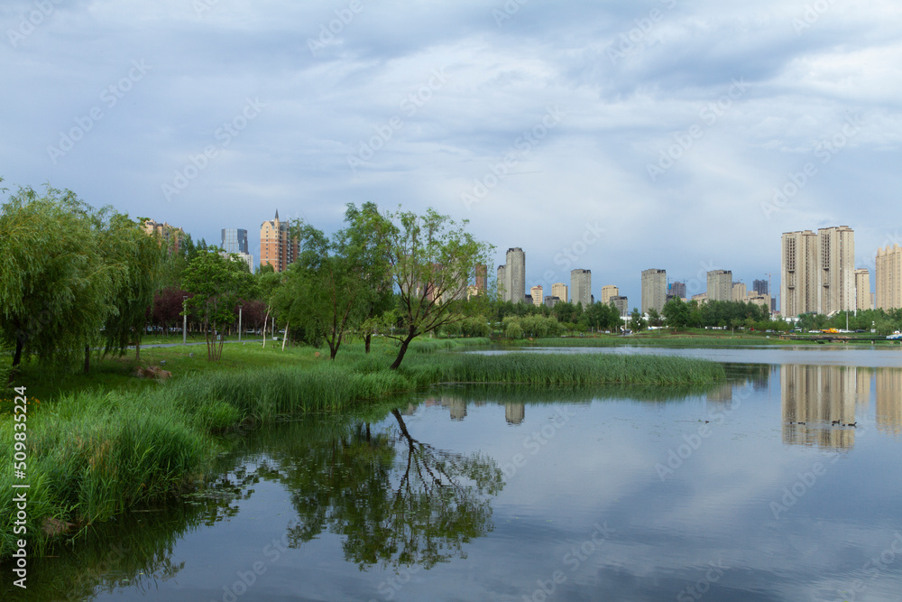 Changchun, Jilin - June 3 2021: Modern apartment building by a city park in summer. Changchun, Jilin - June 3 2021: Modern apartment building by a city park in summer.