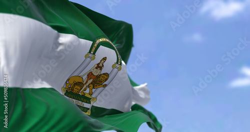 Andalusian flag waving in the wind on a clear day photo