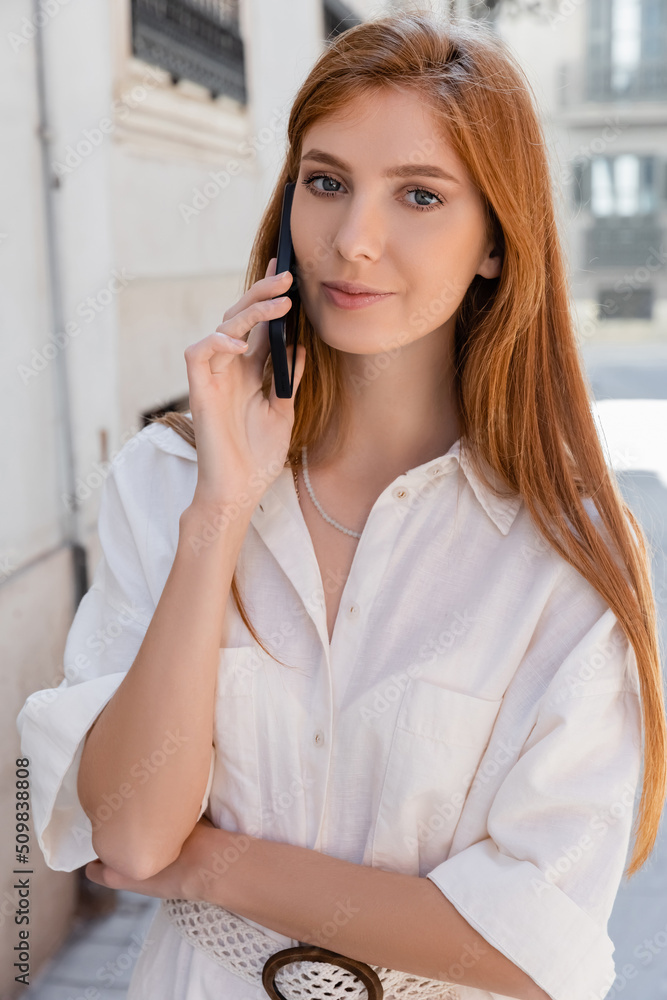portrait of redhead woman talking on mobile phone in valencia. portrait of redhead woman talking on mobile phone in valencia.