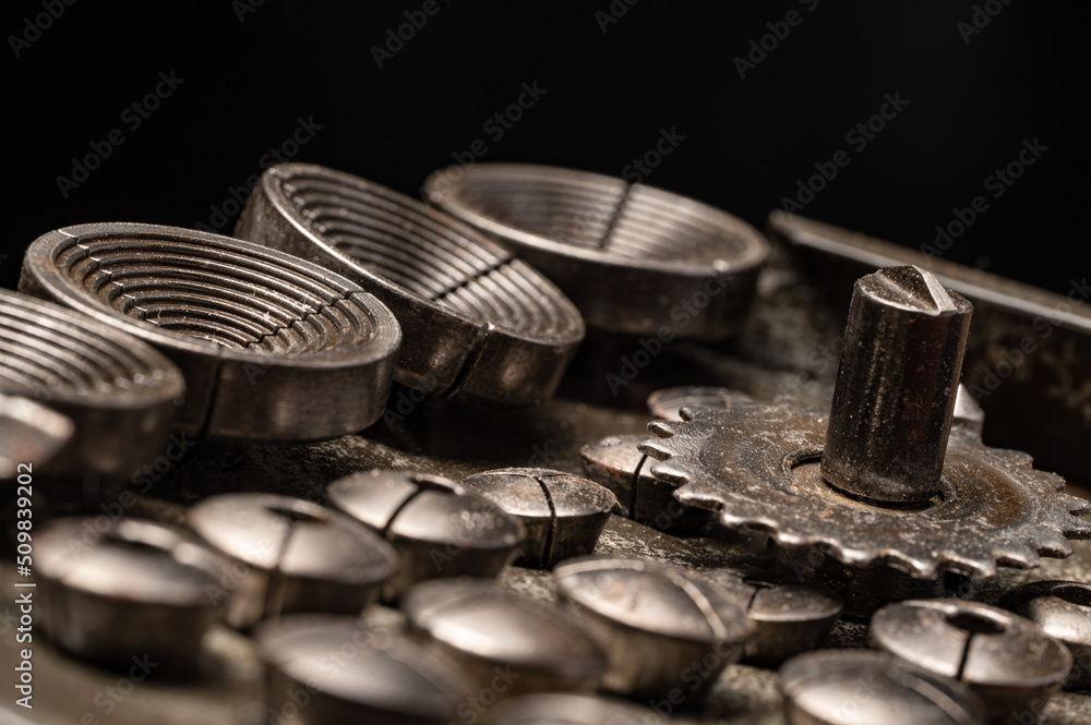 Assortment of steel machinists tooling for metalwork with gears, metal lathe chuck, macro close up details Assortment of steel machinists tooling for metalwork with gears, metal lathe chuck, macro close up details
