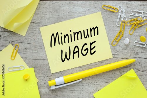 Принти на полотні Minimum wage on paper sticker near paperclips