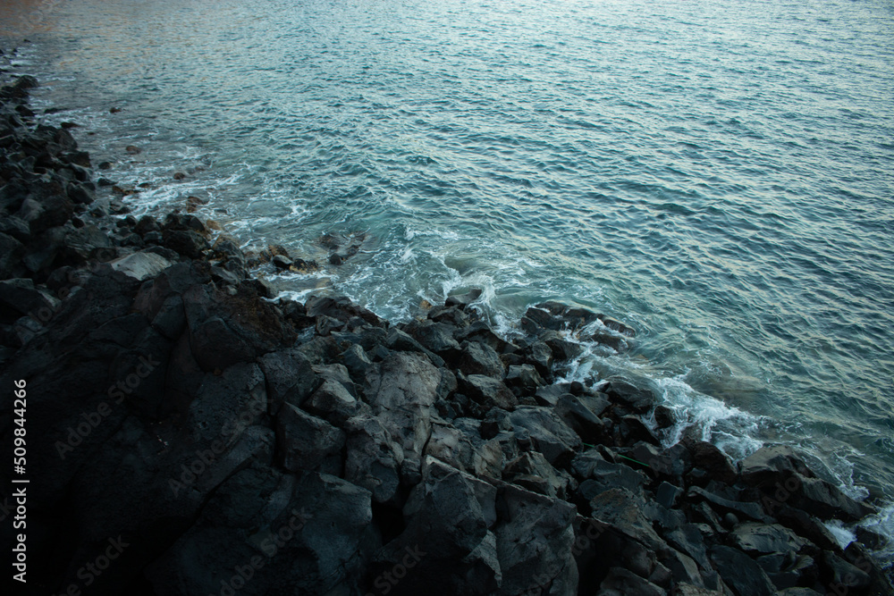 Playa de rocas a la hora del crepúsculo. 