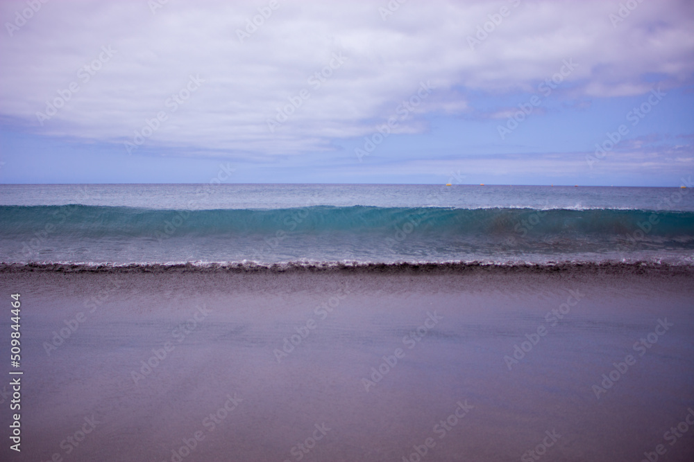 Una ola crea un muro de agua entre la tierra y el mar. 