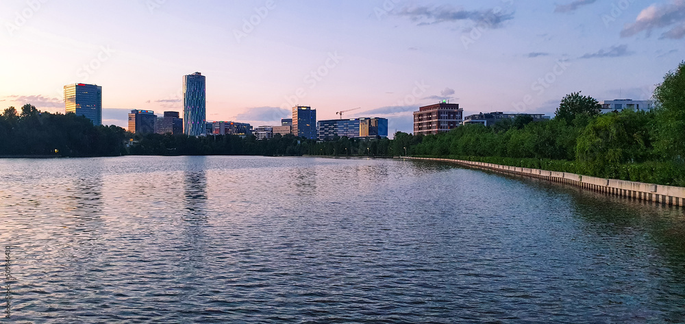 Moderne Bürohochhäuser am Rande eines Sees in der rumänischen Hauptstadt Bukarest am Abend