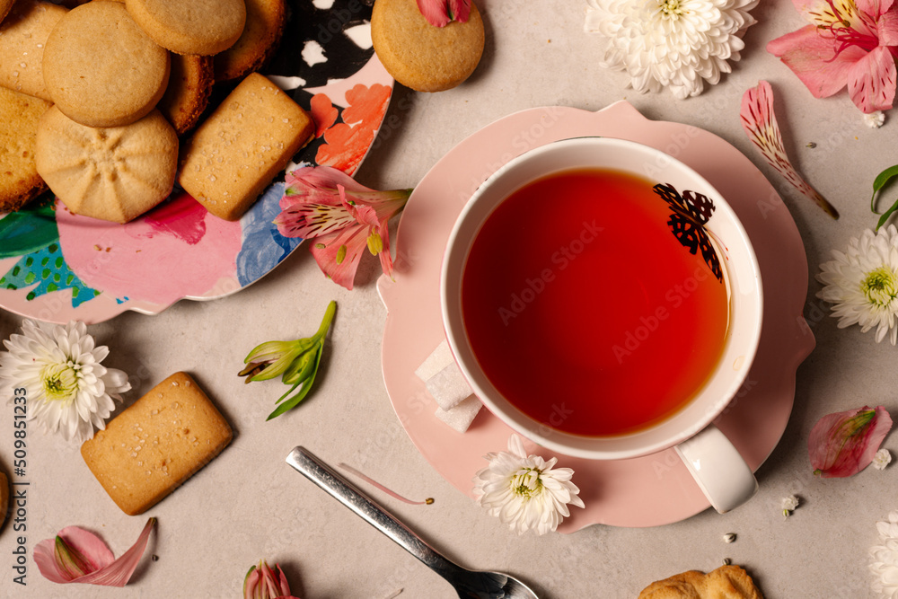 Butterfly pink tea cup and saucer with assorted butter cookies platter and flowers Butterfly pink tea cup and saucer with assorted butter cookies platter and flowers