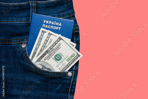 Passport and money in the pocket of denim pants isolate on a pink background with copy space. The concept of fees for travel abroad