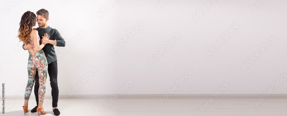 © satura_ - Banner couple dancing social latin dance bachata, merengue, salsa. Two elegance pose on white background copy space