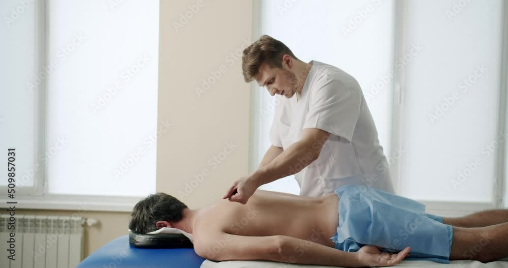 Smart Back Treatment Tools, Therapist Using IASTM Tool to Treat Back Pain, Performing Soft Tissue Release Treatment Manipulations. IASTM Myofascial Release for Relaxing and Treating Pain Muscles, Smart Back Treatment Tools, Therapist Using IASTM Tool to Treat Back Pain, Performing Soft Tissue Release Treatment Manipulations. IASTM Myofascial Release for Relaxing and Treating Pain Muscles,