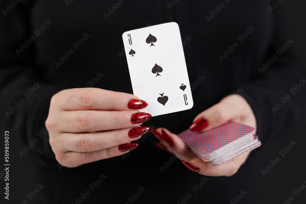 Female hands hold a deck of cards and show tricks. The photographer is ...