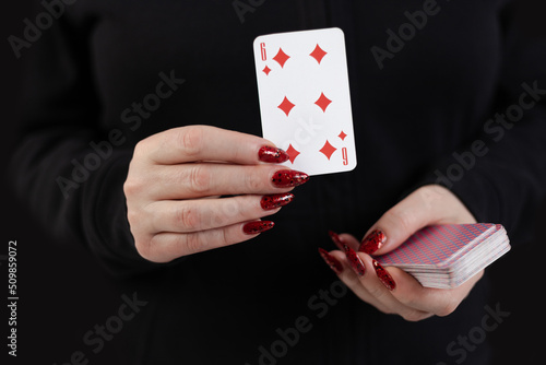 Female hands hold a deck of cards and show tricks.
The photographer is the author of the design of playing cards, which is written in the release of the property. photo