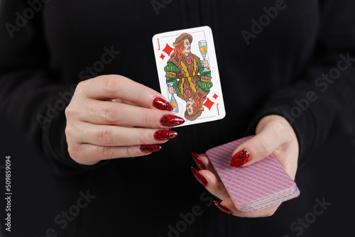 Female hands hold a deck of cards and show tricks.
The photographer is the author of the design of playing cards, which is written in the release of the property. photo