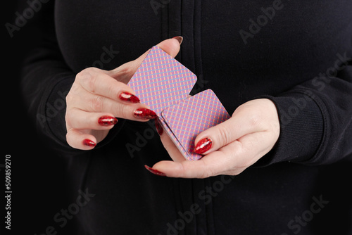 Female hands hold a deck of cards and show tricks.
The photographer is the author of the design of playing cards, which is written in the release of the property. photo