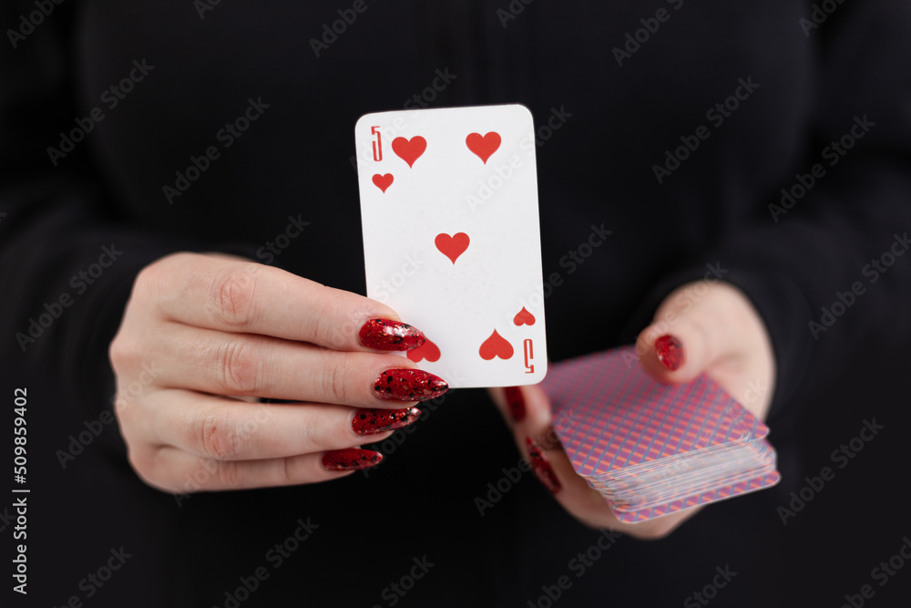 Female hands hold a deck of cards and show tricks. The photographer is ...