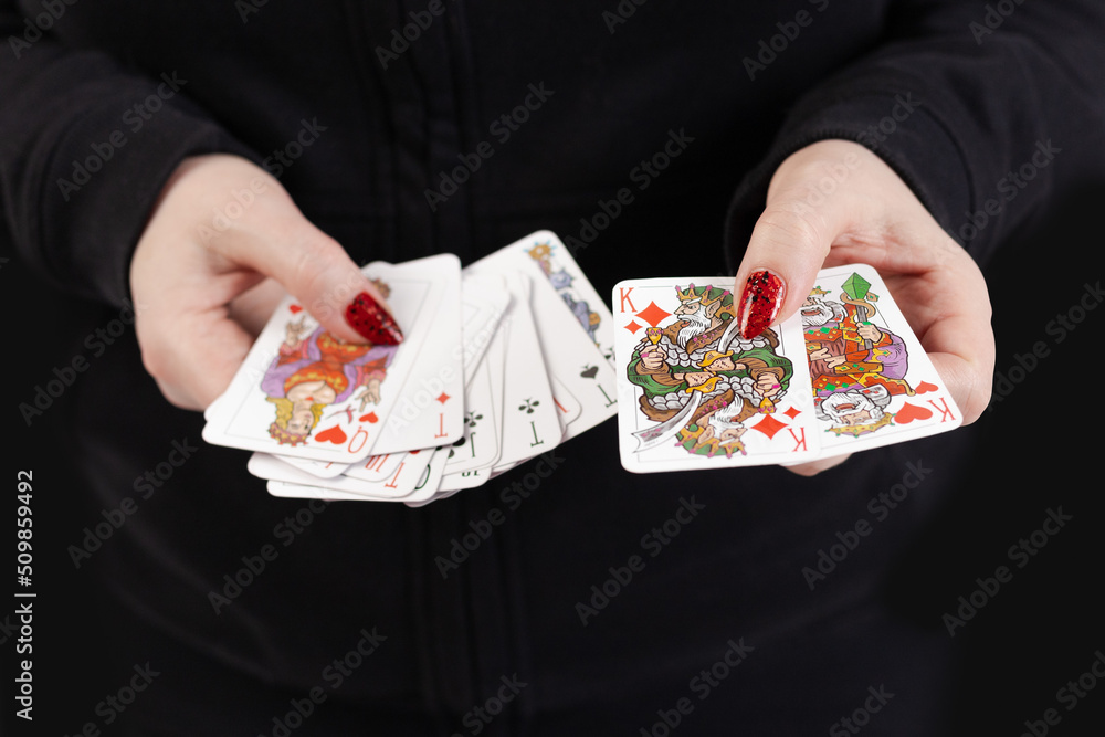 Female hands hold a deck of cards and show tricks. The photographer is ...