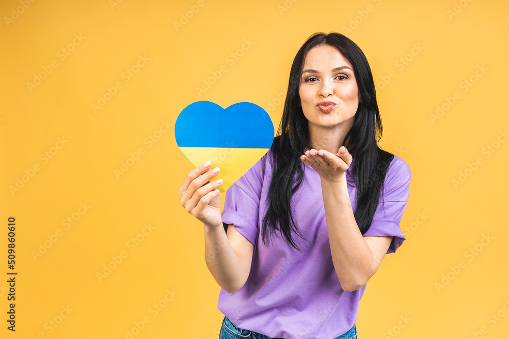 Portrait of nice beautiful lovely glad cheerful woman holding in hands Ukrainian flag having fun isolated over yellow pastel color background.