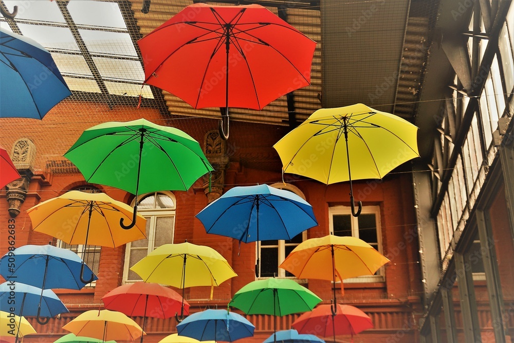 Bunte Regenschirme unter hohem Gebäudedach 