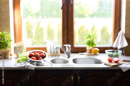 Blurred view of stylish kitchen interior with sink and products