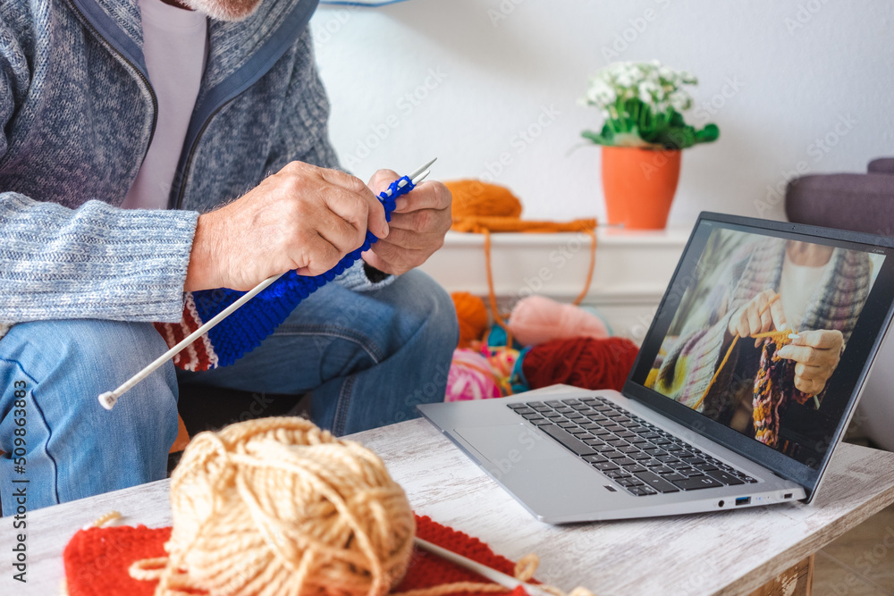 Senior man at home follow online knit tutorial to relax and enjoy resting home leisure activity sitting on the sofa - male people knitting with computer class help - people inner lifestyle hobby Senior man at home follow online knit tutorial to relax and enjoy resting home leisure activity sitting on the sofa - male people knitting with computer class help - people inner lifestyle hobby