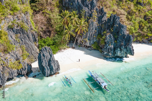 Obraz na płótnie View from above, stunning aerial view of a person on the Entalula Beach, a white sand beach bathed by a crystal clear water. Entalula island, Bacuit Bay, El Nido, Palawan, Philippines. w salonie