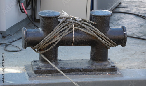 Black metal mooring bollards with a cable wound on them