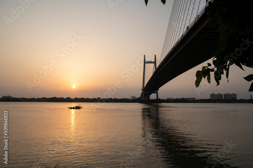 Sunray reflect on the Ganga River beside Hooghly Bridge. Princep Ghat at Kolkata. Beautiful sunset. Beautiful famous Kolkata Hoogly bridge in sunset . light reflection on Ganges top sights.