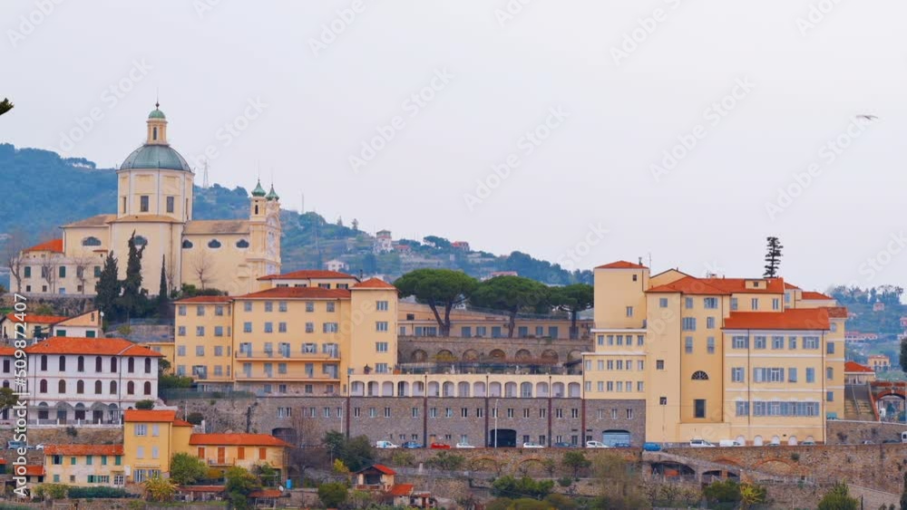 Cityscape of Sanremo, Italy. Residential buildings made in classic style, a church located on a hill Cityscape of Sanremo, Italy. Residential buildings made in classic style, a church located on a hill