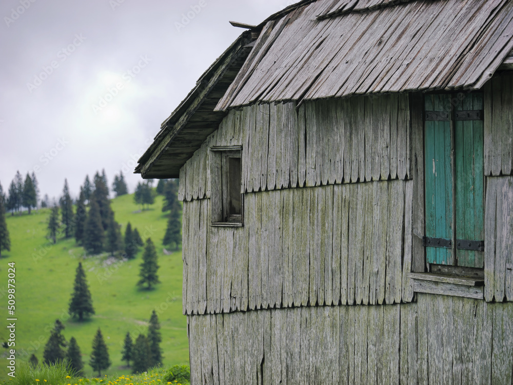 Close-up photo of a traditional Shepard cottage in the valley and the misty sky in the background, Velika Planina, Slovenia