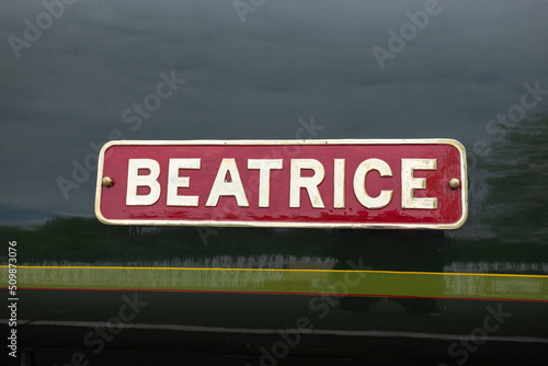 Red sign with white letters saying Beatrice on side of London North Western Railway steam train, Bolton Abbey Steam Railway, UK