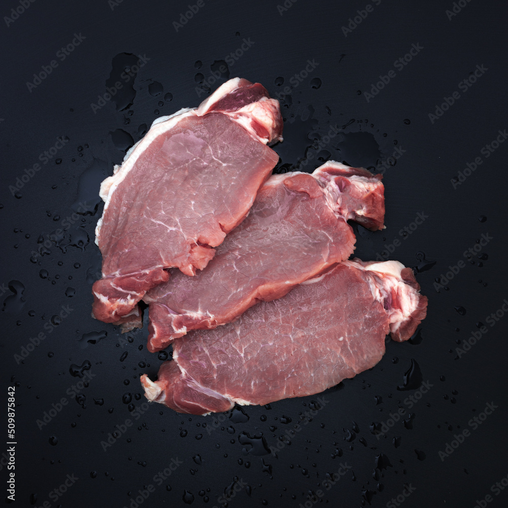 Flat lay with fresh meat on dark background.